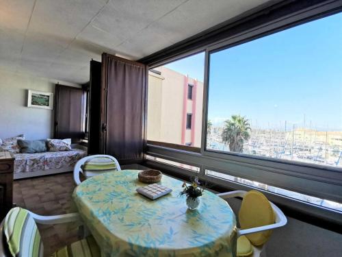 un salon avec une table et une grande fenêtre dans l'établissement Résidence Karukera - 2 Pièces 5 couchages PORT LEUCATE MAE-7214, à Port-Leucate