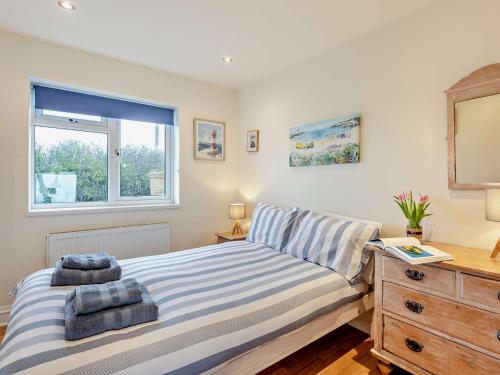 a bedroom with a bed and a dresser and a window at 2 Bed in Seasalter WCC05 in Seasalter