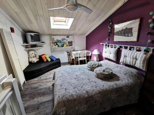 - une chambre avec un lit et un mur violet dans l'établissement Résidence Le Mykonos - APPT T2 CAB OU MEZZ 6 couchages PORT LEUCATE. Réf: 2MYK_15C MAE-7254, à Port-Leucate
