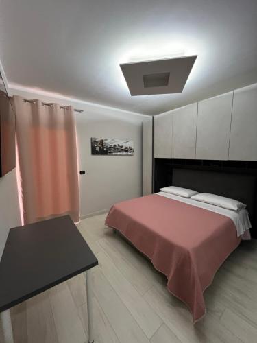 ein Schlafzimmer mit einem Bett und einem Tisch darin in der Unterkunft Brass apartment in Castellammare di Stabia