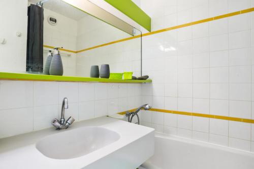 La salle de bains blanche est pourvue d'un lavabo et d'une baignoire. dans l'établissement Résidence le Village de Cap Esterel - maeva Home - Appartement 2 pièces 5 personnes - Sélection MAE-7252, à Saint-Raphaël