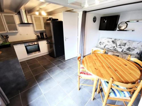une cuisine et une salle à manger avec une table et un réfrigérateur dans l'établissement Résidence Grande Bleue - VILLA T2 MEZZANINE 6 couchages PORT LEUCATE MAE-7264, à Port-Leucate