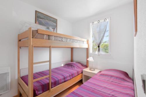 une chambre avec deux lits superposés et une fenêtre dans l'établissement Résidence Port Bourgenay - maeva Home - Appartement moderne 2 pièces 5 personnes - Prestige - super Home MAE-2308, à Talmont-Saint-Hilaire