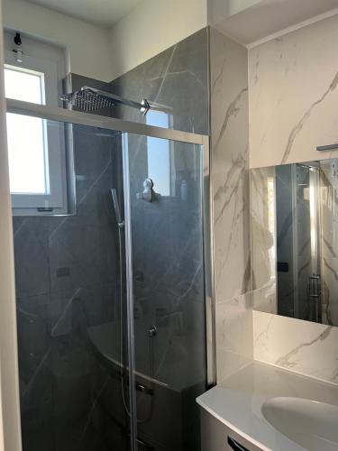 ein Bad mit einer Dusche und einem Waschbecken in der Unterkunft Brass apartment in Castellammare di Stabia