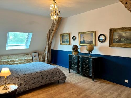 een slaapkamer met een bed en een blauwe muur bij Château de la Pervenchère gîte Marin in Casson