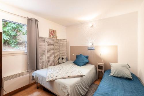 um quarto com 2 camas e uma janela em Village Pont Royal en Provence - maeva Home - Appartement ravissant 3 Pièces 7 em Mallemort