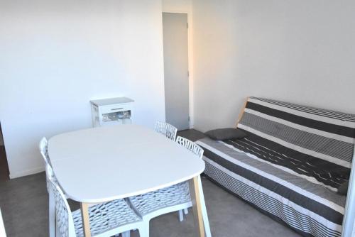 Cette petite chambre comprend une table blanche et un lit. dans l'établissement Résidence PORTES DE LA PLAGE 2 - 2 Pièces pour 4 Personnes 54, à Port-Leucate
