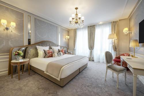 a hotel room with a large bed and a desk at Hotel Westminster in Paris