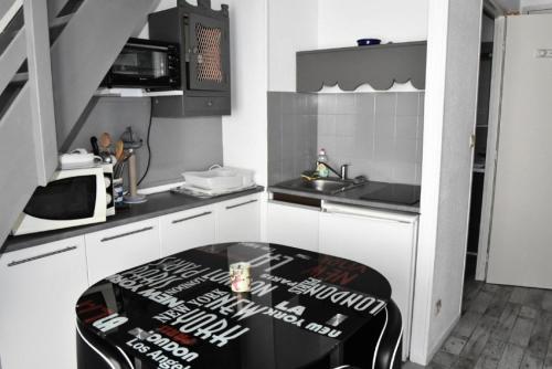 une cuisine avec une table au milieu dans l'établissement Résidence Les Portes De La Mediterranee - STUDIO 4 PERSONNES 4 couchages PORT LEUCATE MAE-7414, à Port-Leucate