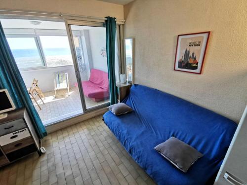 une chambre avec un lit bleu et un balcon dans l'établissement Résidence LES NEFS DES SABLES - Studio pour 5 Personnes 34, à Port-Leucate