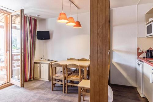 une cuisine et une salle à manger avec une table et des chaises dans l'établissement Résidence Les Fontaines Blanches - maeva Home - Studio 4 personnes Confort MAE-5200, à Morzine
