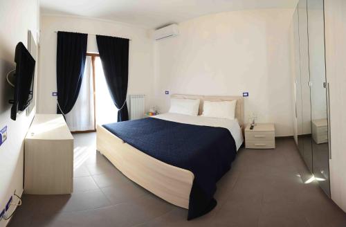 a bedroom with a large bed and a television at Flat House in Fiumicino