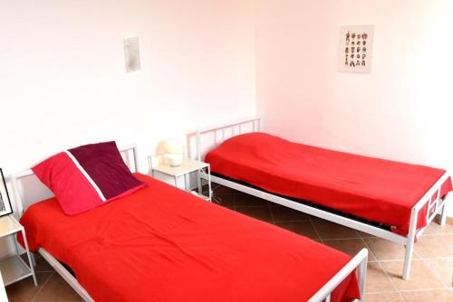 2 camas en una habitación blanca con sábanas rojas en Résidence LES CANDEILLERES - Maisons & Villas pour 6 Personnes 94, en Port Leucate