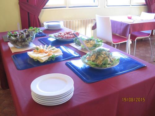 a table with plates and bowls of food on it at Hotel Le Commerce in Neuville