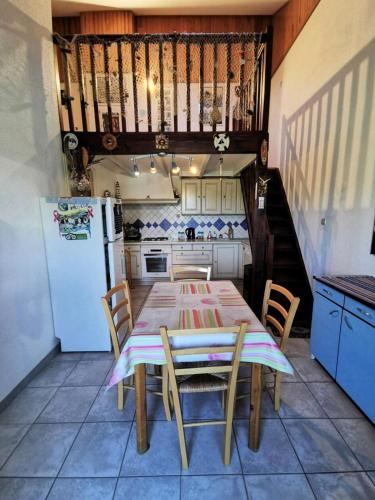une cuisine avec une table, des chaises et un réfrigérateur dans l'établissement Résidence Village Merlin - VILLA T2 MEZZANINE 4 couchages PORT LEUCATE MAE-6954, à Port-Leucate