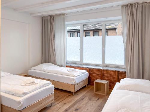 a room with three beds and a window at T&K Apartments - 5 Zimmer Einfamilienhaus 15min to Messe Fair DUS - Willich in Willich