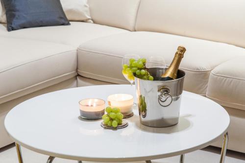 a table with a bucket of wine and grapes on it at Apartments Deja Views - Žnjan beach in Split