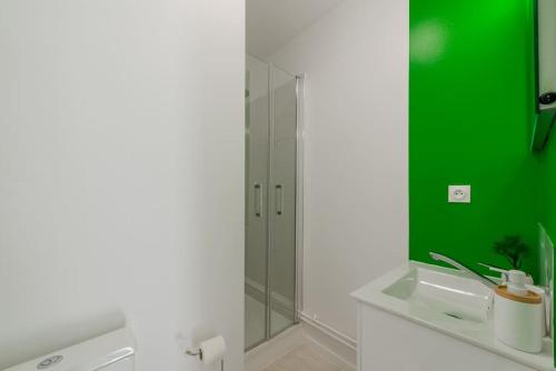 La salle de bains est pourvue d'un lavabo et d'un miroir vert. dans l'établissement La Place de Toscane 1, à Serris