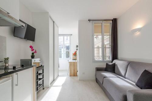 un salon avec un canapé et une cuisine dans l'établissement La Place de Toscane 1, à Serris