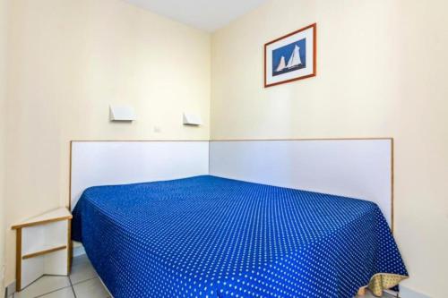 - une chambre avec un lit bleu dans l'établissement Résidence le Hameau de Cap Esterel - maeva Home - Appartement 2 Pièces 5 Personnes - Sélection MAE-9687, à Saint-Raphaël
