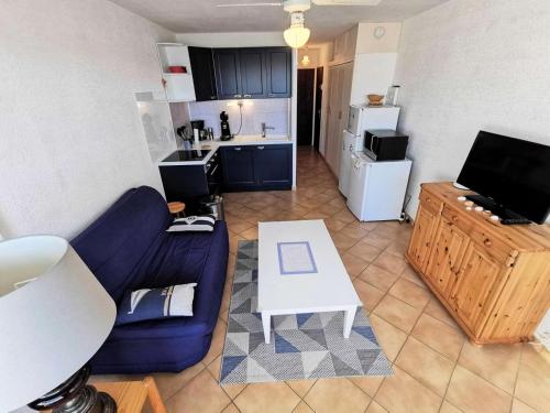 - un salon avec un canapé bleu et une table blanche dans l'établissement Résidence Les Voiliers - 2 Pièces 4 couchages PORT LEUCATE MAE-3084, à Port-Leucate