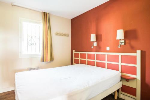 une chambre avec un lit blanc et une fenêtre dans l'établissement Résidence Les Parcs de Grimaud - maeva Home - Appartement 2 Pièces 5 Personnes - Confort MAE-0275, à Grimaud