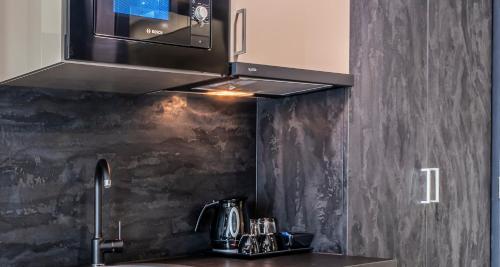 een keuken met een wastafel en een fornuis top oven bij Best Western Plus Grand Winston in Rijswijk