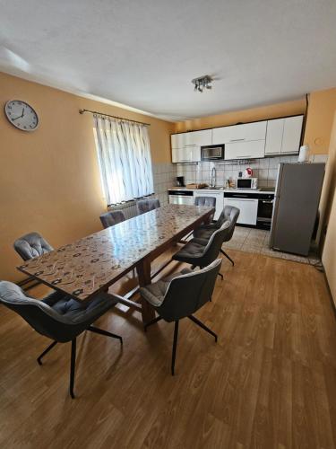 una gran mesa de comedor con sillas y una cocina en House Mirjana, en Smoljanac