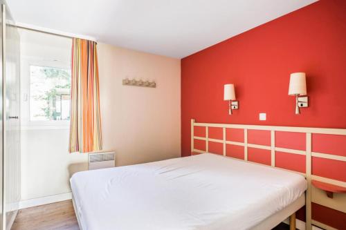 een slaapkamer met een wit bed en rode muren bij Résidence Les Parcs de Grimaud - maeva Home - Appartement 2 Pièces 4 Person 89 in Grimaud