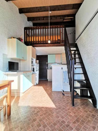 une cuisine avec un escalier en colimaçon dans une maison dans l'établissement Résidence Cote D'oc - 2 Pièces pour 4 Personnes 104, à Port-Leucate