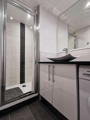 La salle de bains est pourvue d'un lavabo et d'une douche avec baignoire. dans l'établissement Résidence Le Mail A La Plage - APPT T2 4 couchages PORT LEUCATE. Réf: 2MAI_603 MAE-3184, à Port-Leucate