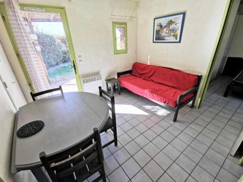 sala de estar con sofá rojo y mesa en Résidence Ile Des Pecheurs - Maisons & Villas pour 6 Personnes 114, en Port Leucate