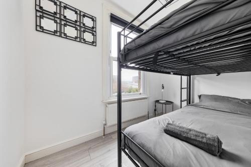 a bedroom with a bunk bed and a large window at Stylish 2-Bedroom Flat in Walthamstow in London