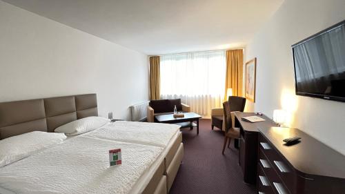 Cette chambre comprend un lit et un bureau. dans l'établissement Landhotel Weisses Ross garni, à Bad Brückenau