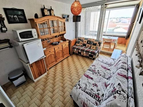 une chambre avec un lit et une cuisine avec un four micro-ondes dans l'établissement Résidence Karukera - 2 Pièces 4 couchages PORT LEUCATE MAE-3134, à Port-Leucate