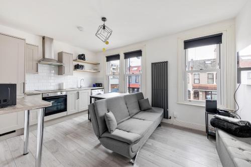 a living room with a couch and a kitchen at Stylish 2-Bedroom Flat in Walthamstow in London