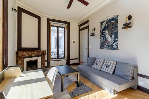 un salon avec un canapé et une table dans l'établissement Hamac Suites - Le Pleney, à Lyon