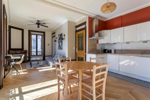 une cuisine et un salon avec une table et des chaises dans l'établissement Hamac Suites - Le Pleney, à Lyon