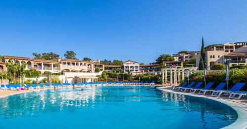 une piscine dans un complexe hôtelier avec chaises et condos dans l'établissement Résidence Les Parcs de Grimaud - maeva Home - Studio 5 Personnes - Confort MAE-0295, à Grimaud