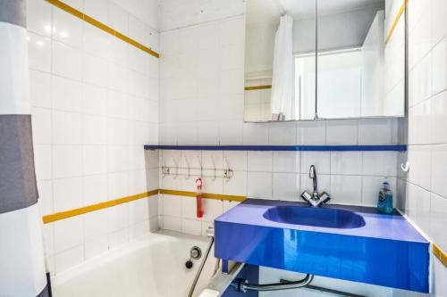 La salle de bains est pourvue d'un lavabo bleu et d'une baignoire. dans l'établissement Résidence Les Parcs de Grimaud - maeva Home - Studio 5 Personnes - Confort MAE-0295, à Grimaud