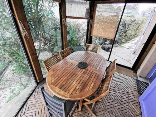 - une table et des chaises en bois sur une terrasse couverte dans l'établissement Résidence Ile Des Pecheurs - VILLA 3 PIECES 6 couchages LE BARCARES MAE-1314, à Port-Leucate