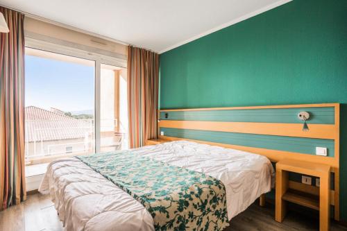 une chambre avec un lit et un mur végétal dans l'établissement Résidence Cap Hermes - maeva Home - Appartement 2 Pièces 6 Personnes - Selection MAE-0325, à Fréjus