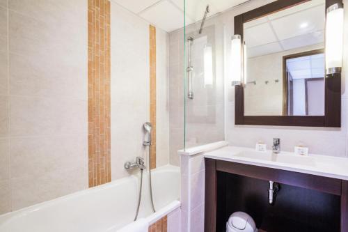 une salle de bain avec une baignoire, un lavabo et un miroir dans l'établissement Résidence Cap Hermes - maeva Home - Appartement 2 Pièces 6 Personnes - Selection MAE-0325, à Fréjus