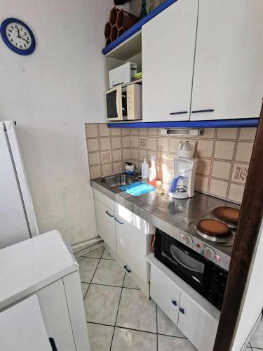 une cuisine avec des armoires blanches et un comptoir dans l'établissement Résidence Les Barcarelles - VILLA T2 CABINE 4 couchages LE BARCARES MAE-1334, à Port-Leucate