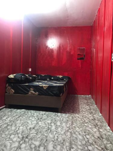 1 dormitorio con 1 cama en una pared roja en The Big Boss Indian & Nepali Restaurant house, en Sihanoukville