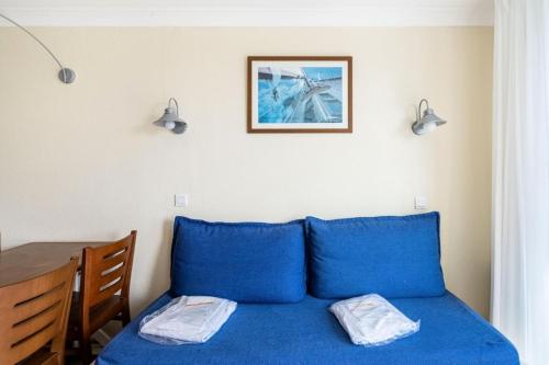 - un lit avec des oreillers bleus dans l'établissement Résidence Bleu Marine - maeva Home - Appartement 2 Pièces 4 Personnes - Confort MAE-0547, à Lacanau