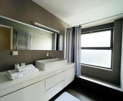 een badkamer met een witte wastafel en een spiegel bij Penthouse with Private Pool in Athene