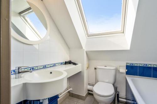 La salle de bains est pourvue d'un lavabo, de toilettes et d'une fenêtre. dans l'établissement Résidence Cap Azur - maeva Home - Appartement duplex 2 Pièces 5 Personnes Sélection - Vue mer MAE-1182, à Fouesnant