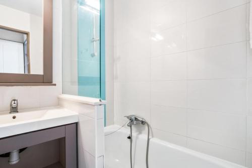 une salle de bain blanche avec un lavabo et une douche dans l'établissement Résidence Cannes Verrerie - maeva Home - Appartement 3 Pièces 6 Personnes - Sélection MAE-4213, à Cannes