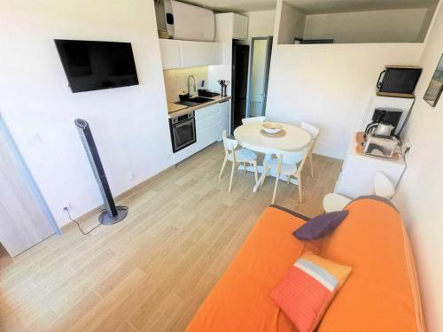 un salon avec un canapé orange et une table dans l'établissement Résidence Le Cezelly - 2 Pièces cabine 5 couchages PORT LEUCATE. Réf: 4CEZ_6C MAE-6634, à Port-Leucate